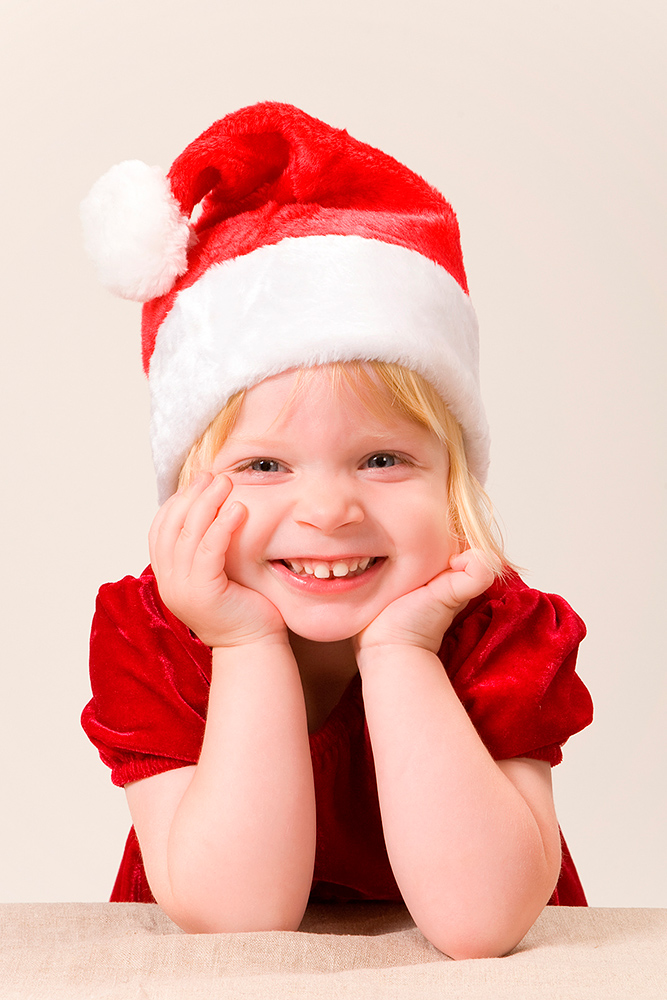Julefoto af sød pige i nissehue og rød kjole af palle christensen